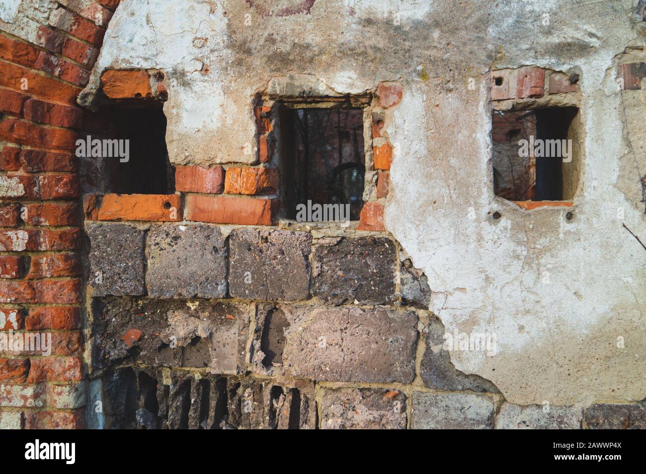 Small windows in red brick wall of old ruined building Stock Photo