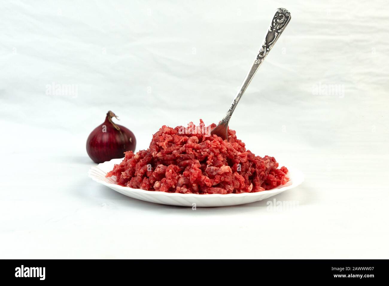 Carnivore diet. Raw ground beef lies on a plate. Minced meat. Conception carnivor. Stock Photo