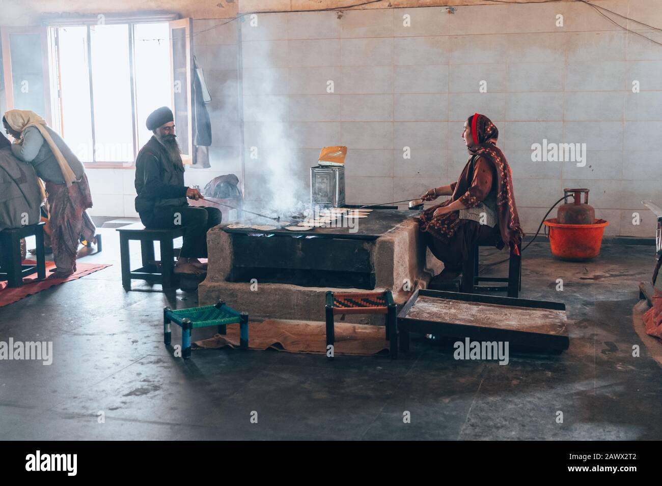 Amritsar India - Febuary 8, 2020: Sikh man and Indian woman prepare chapati - traditional Indian bread at the Golden Temple (sri harmandir sahib) Stock Photo