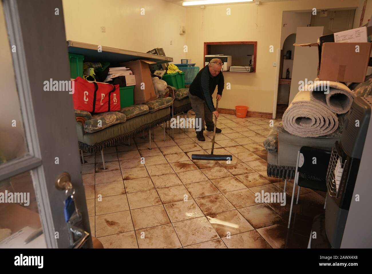 Keith Bainbridge, 66, a volunteer for North West Ambulance Service, cleans up the Appleby and District Community First Responder Group premises in Appleby-in-Westmorland, Cumbria, in the aftermath of Storm Ciara which lashed the country Sunday. Stock Photo