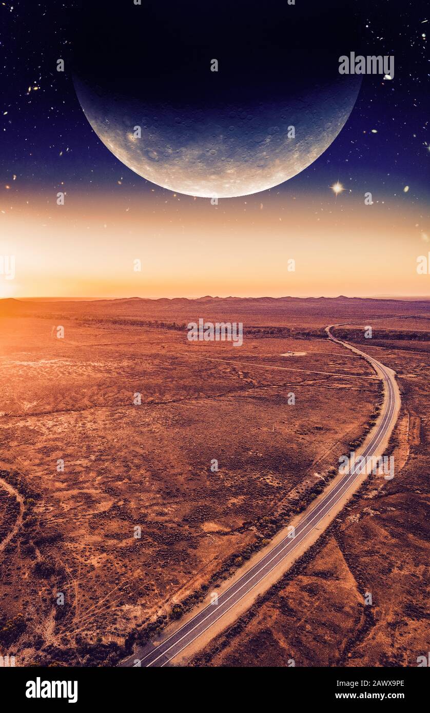 Book cover template. Unreal landscape - dark planet over road winding through desert landscape at sunset. Elements of this image are furnished by NASA Stock Photo