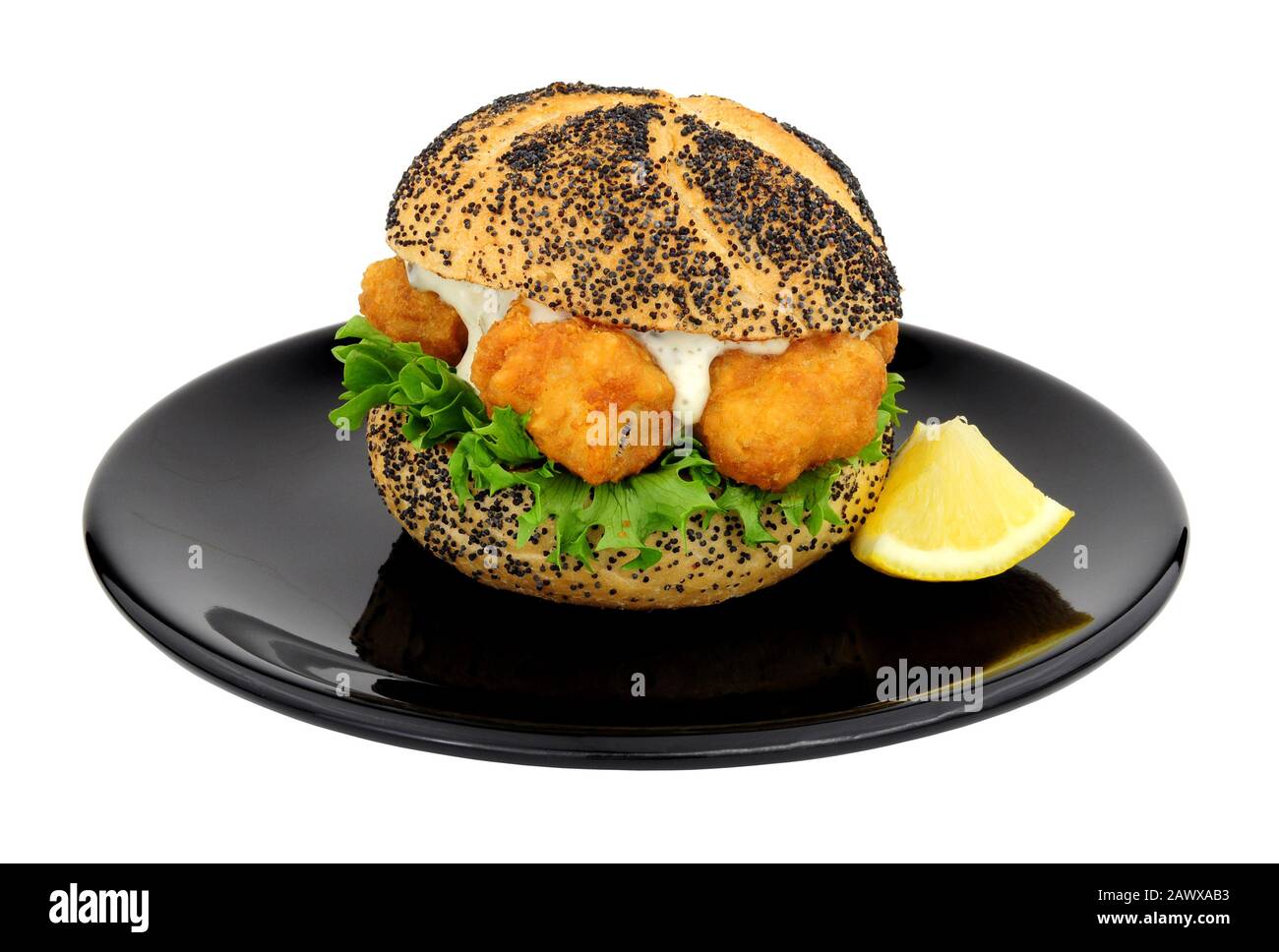 Battered cod fish nugget sandwich with tartare sauce and lettuce on a black plate isolated on a white background Stock Photo