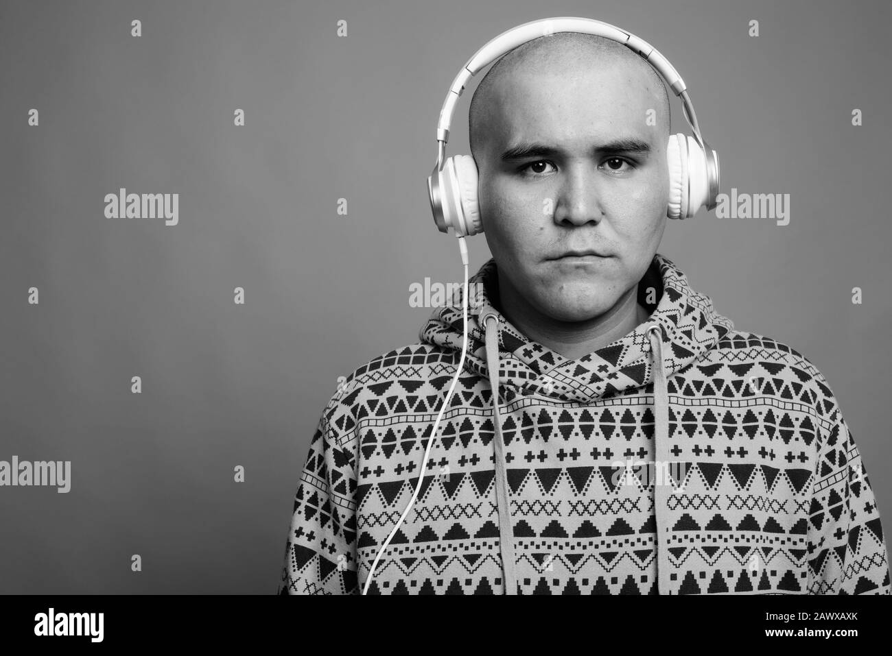 Portrait of young bald Asian man listening to music Stock Photo - Alamy