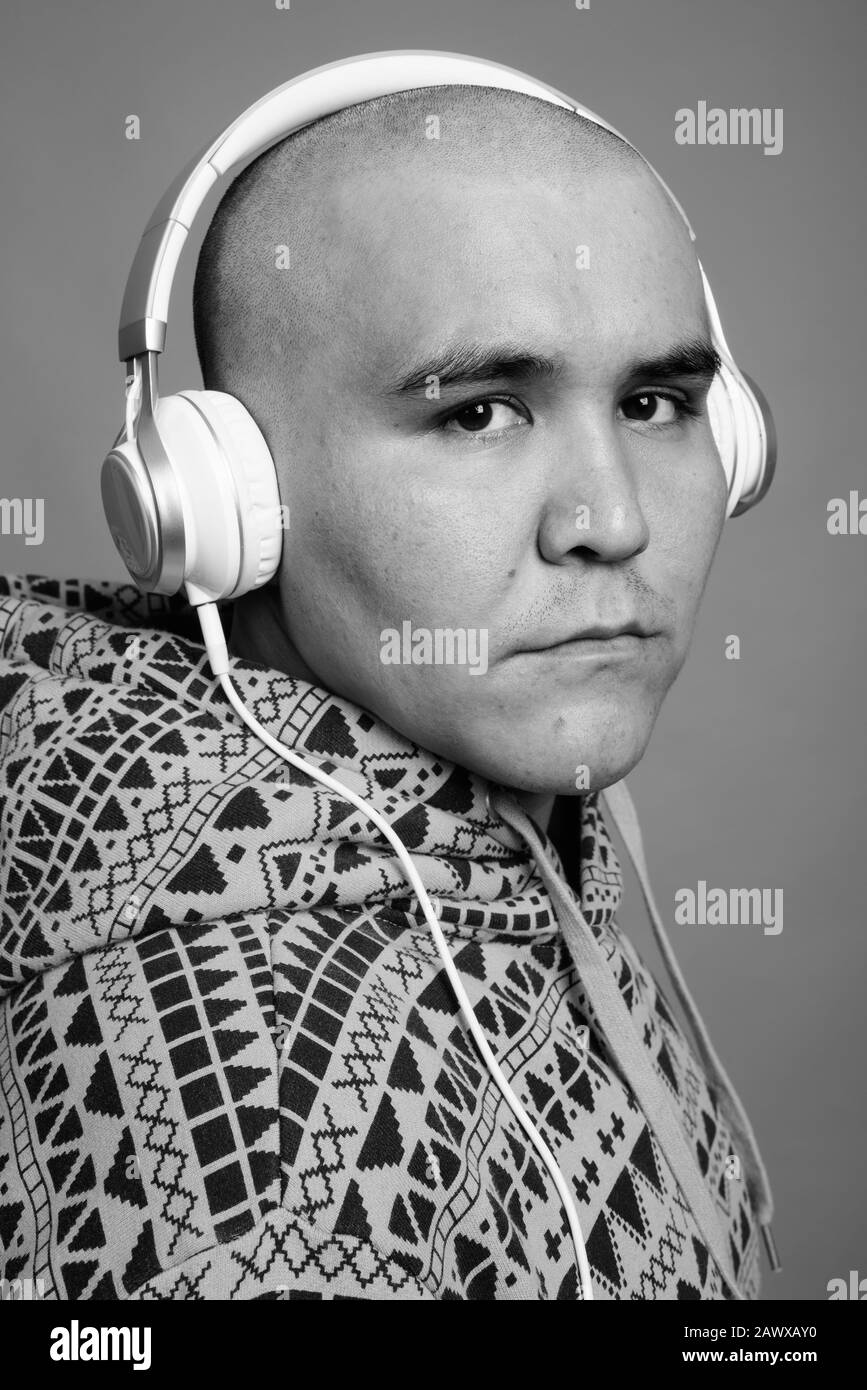 Portrait of young bald Asian man listening to music Stock Photo - Alamy