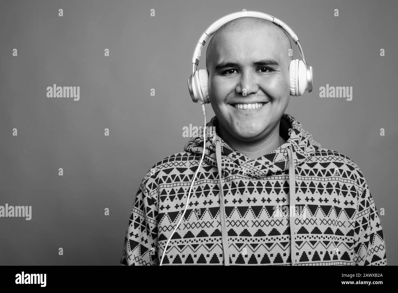 Portrait of young bald Asian man listening to music Stock Photo - Alamy