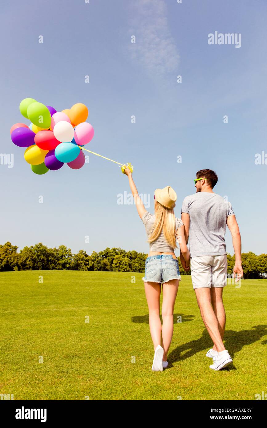 Two Friends Back Back view of two friends walking in park with balloons Stock Photo - Alamy