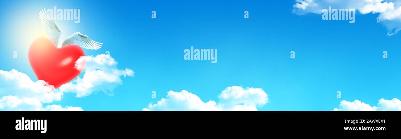 Heart with wings flying above clouds.  Panoramic banner with wide space for text or design. Stock Photo