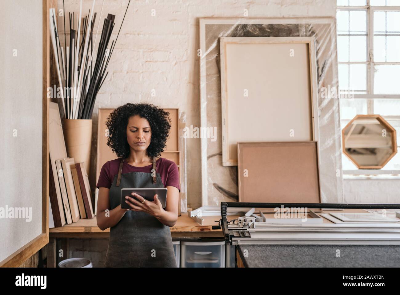 Young woman using a tablet in her framing studio Stock Photo