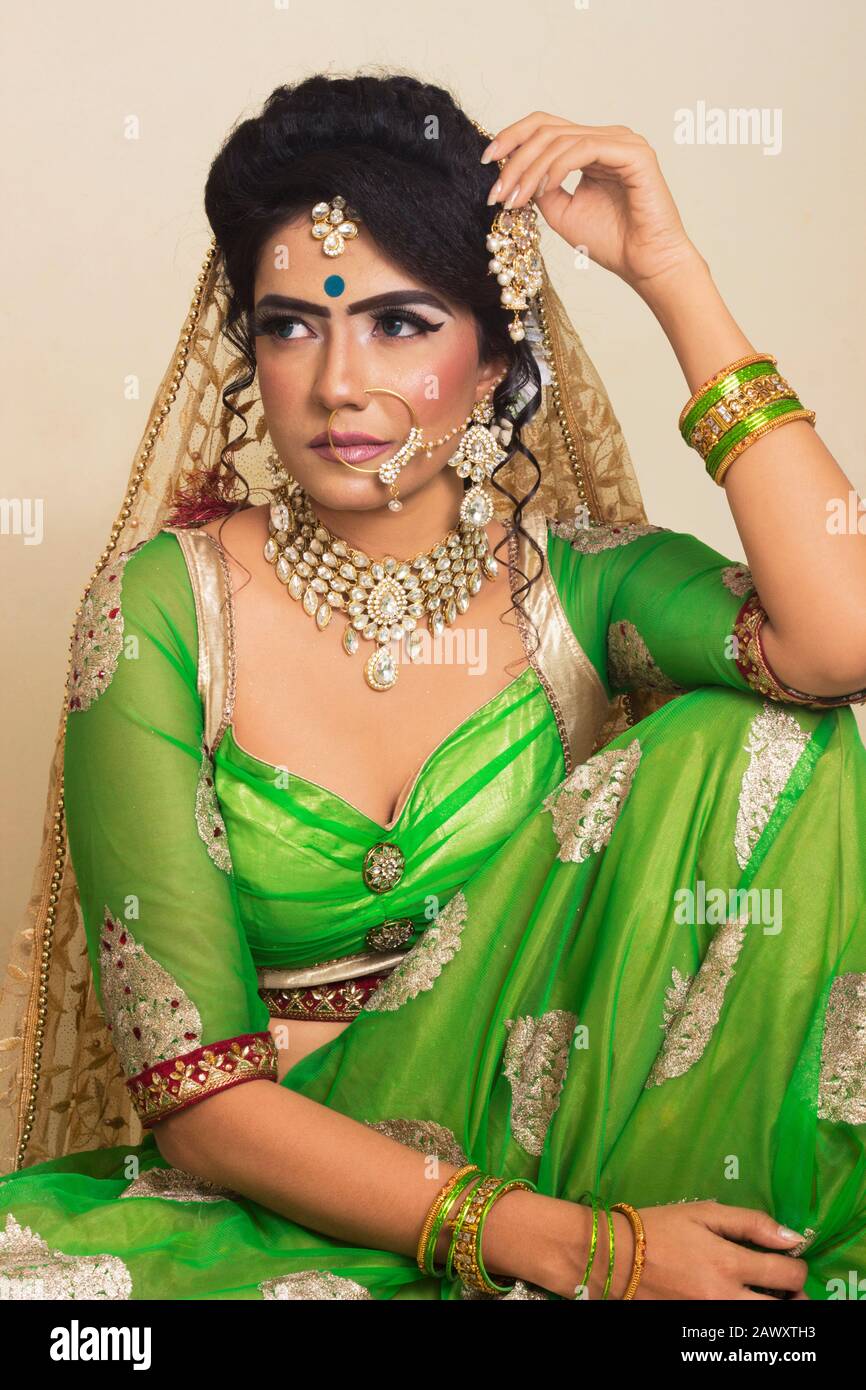 Female Model in traditional Indian Asian bridal wedding costume with makeup  and jewelry looking at camera closeup Stock Photo - Alamy