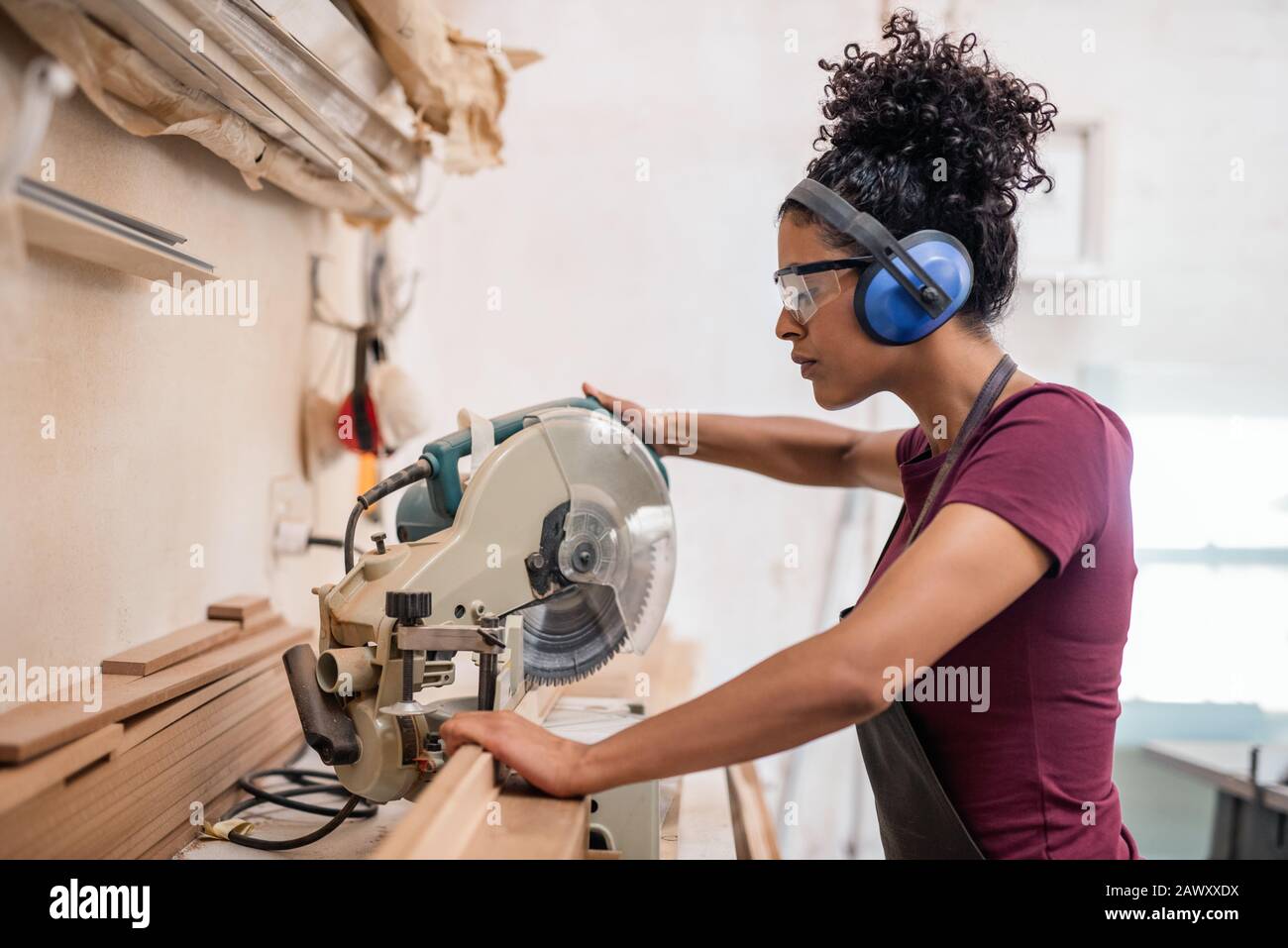 Female artisan cutting wood in her framing workshop Stock Photo