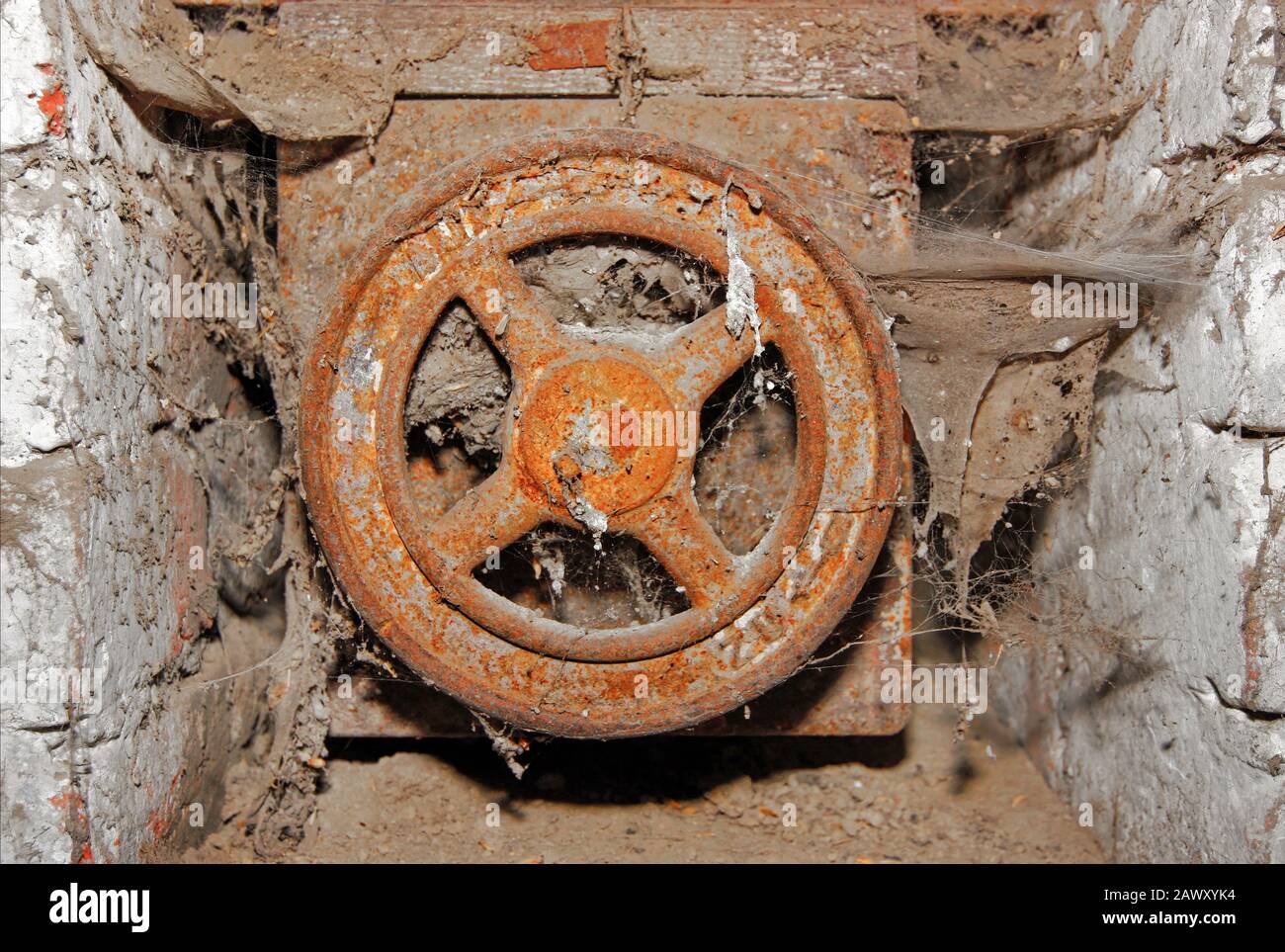 Old rusty round valve covered with spider web Stock Photo