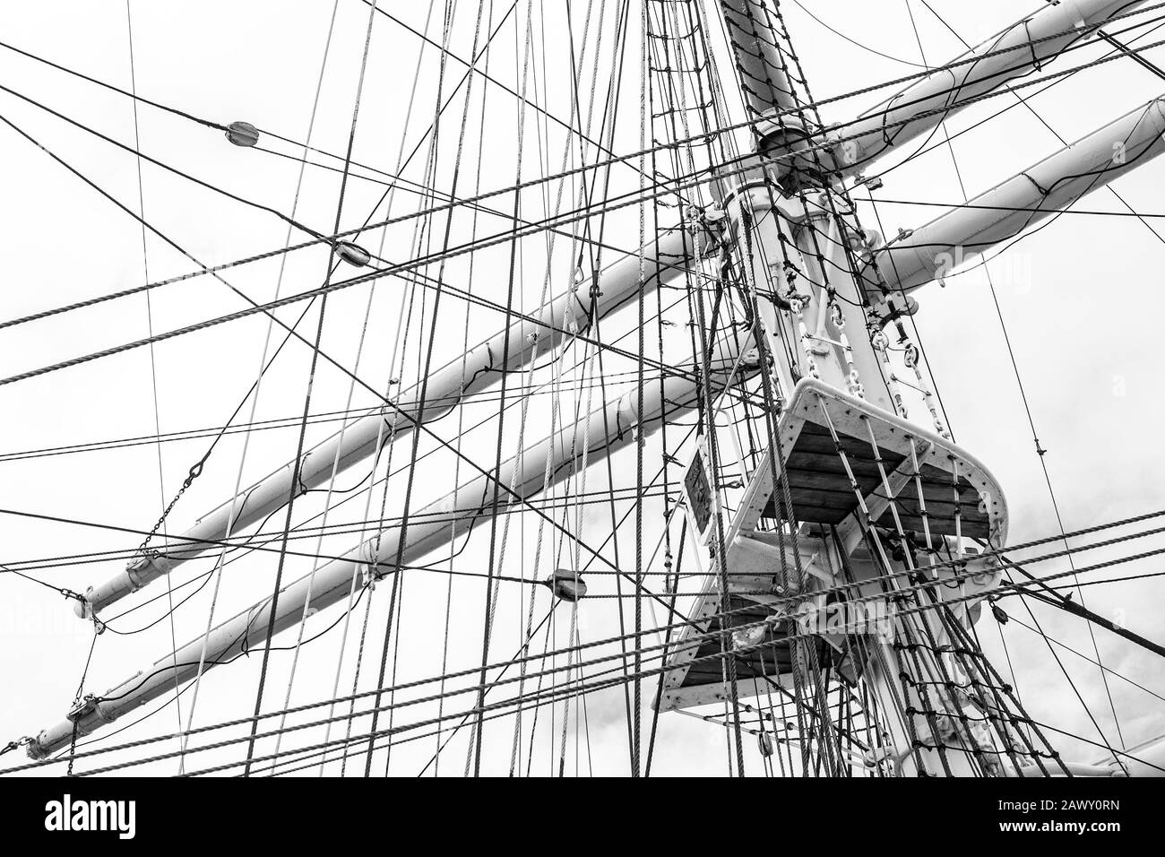 Monochrome image of mast with rigging and rolled up sails of old polish sailing ship Dar Pomorza Stock Photo