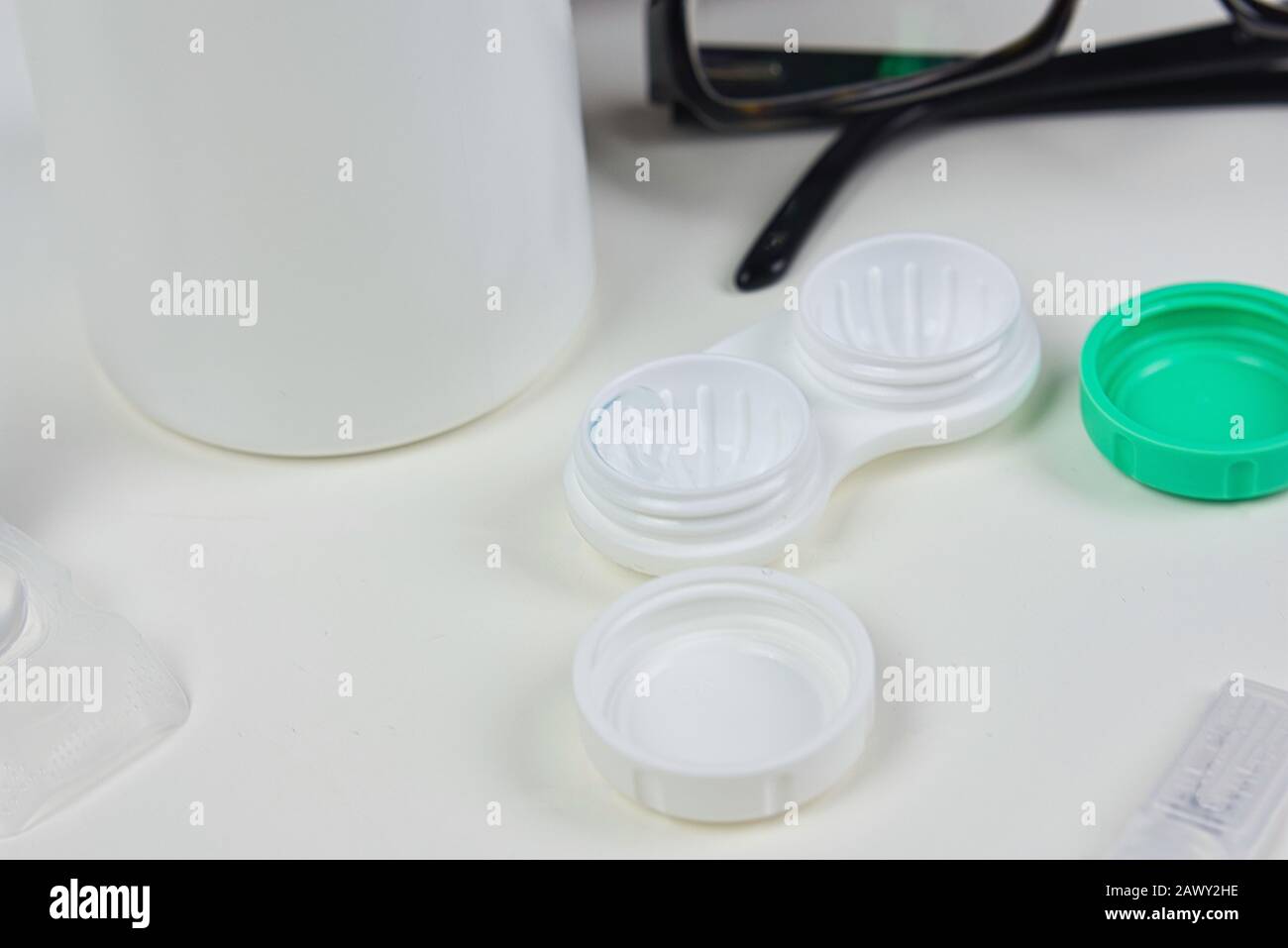 Contact lens case flat lay up close with other eye wear products including glasses and solution Stock Photo