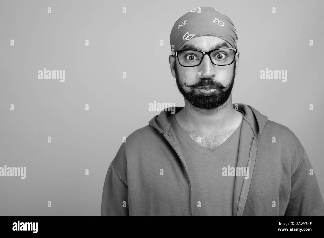 Portrait of young handsome bearded Indian man with eyeglasses Stock Photo