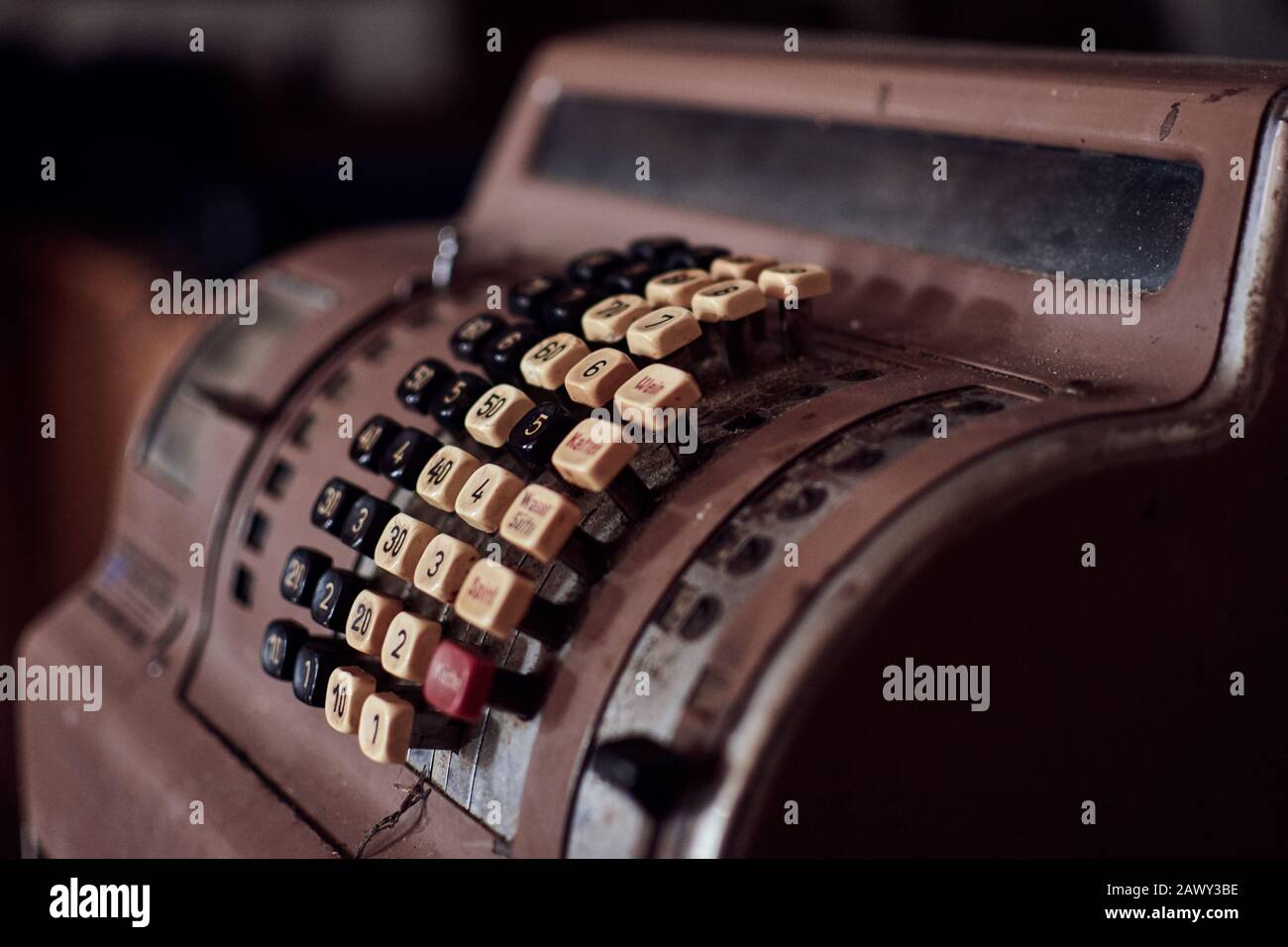 Vintage cash register. Close-up of a brown and ancient restaurant till with many yellowed buttons. Stock Photo