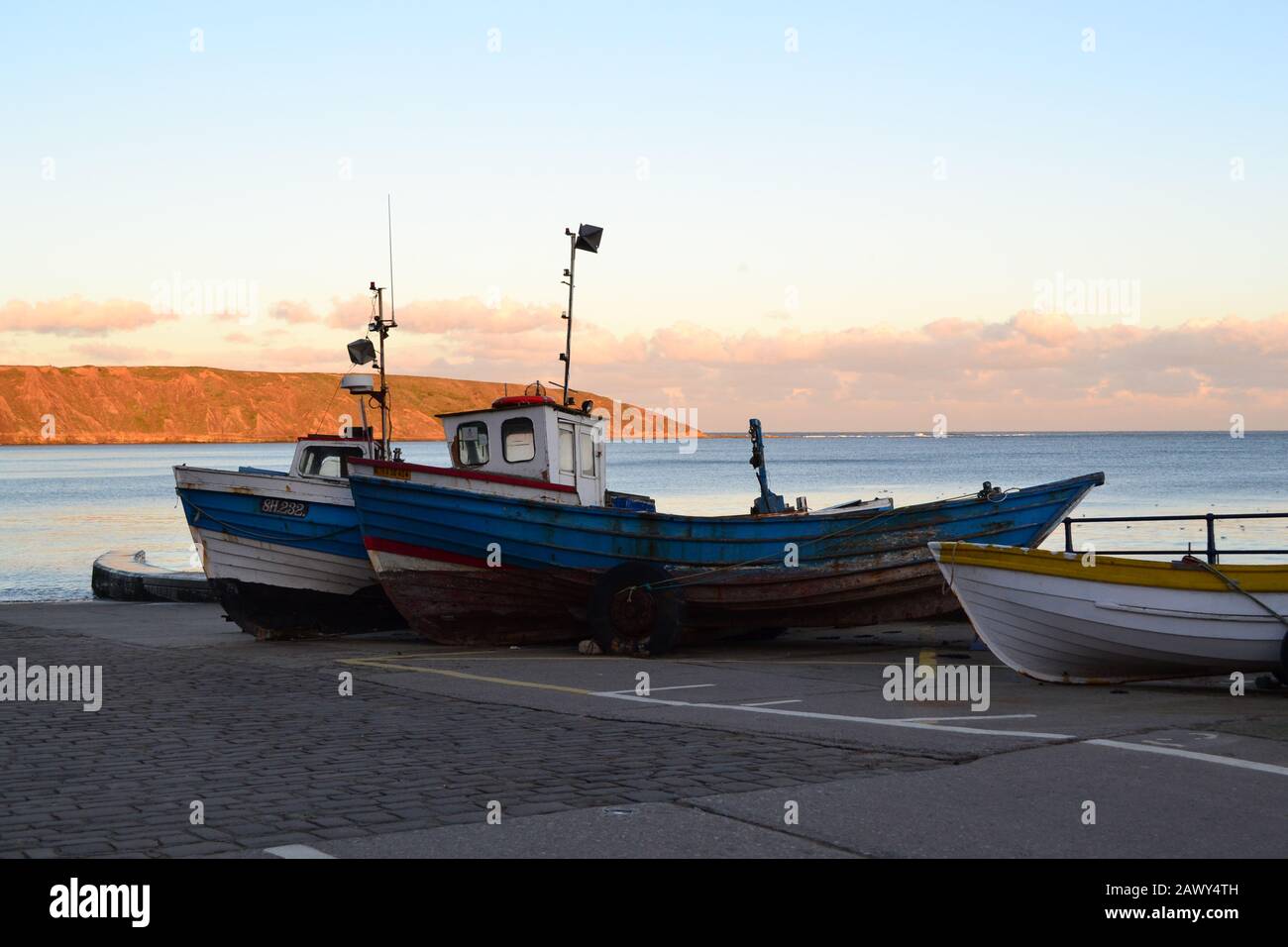 Old Coble Boats On Coble Landing - Filey Seafront - Filey Brigg, Blue Sky And Calm North Sea - North Yorkshire UK Stock Photo