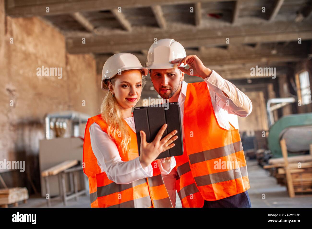 Engineers in wooden factory working on digital tablet Stock Photo