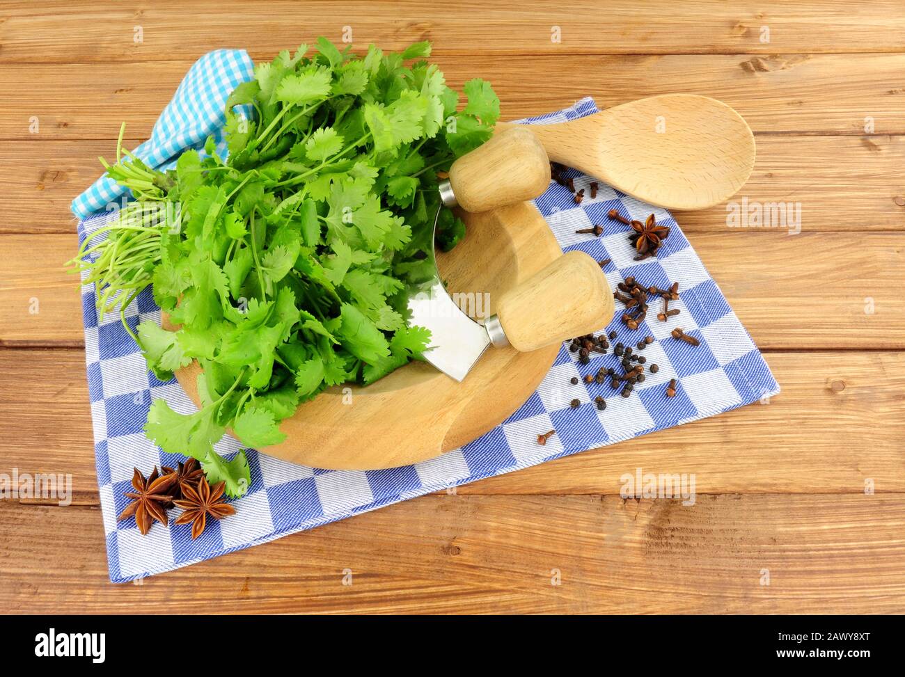 Bunch of fresh coriander on a wooden herb chopping board Stock Photo