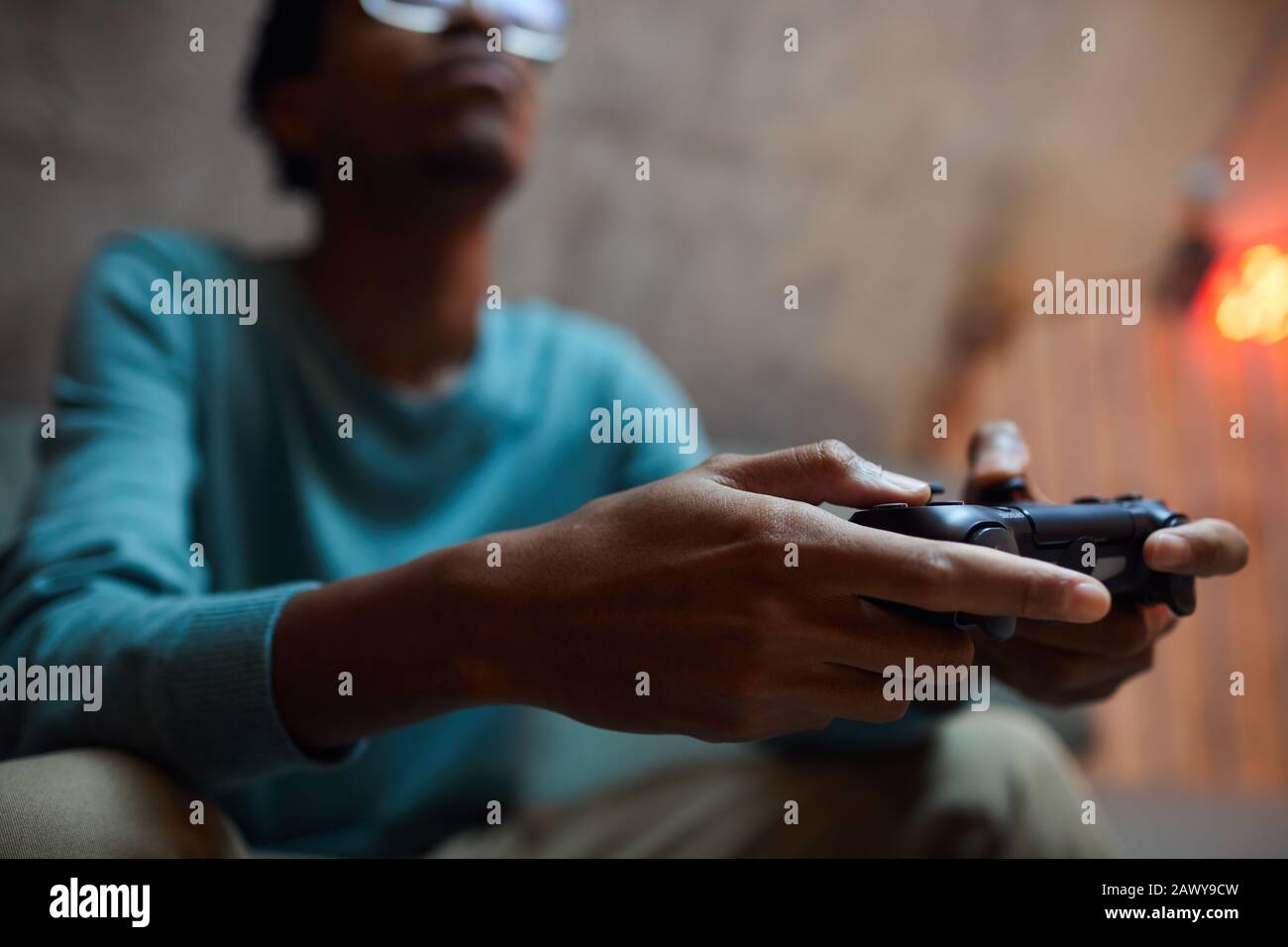 Close up of contemporary African-American man holding gamepad controller while playing videogames Stock Photo