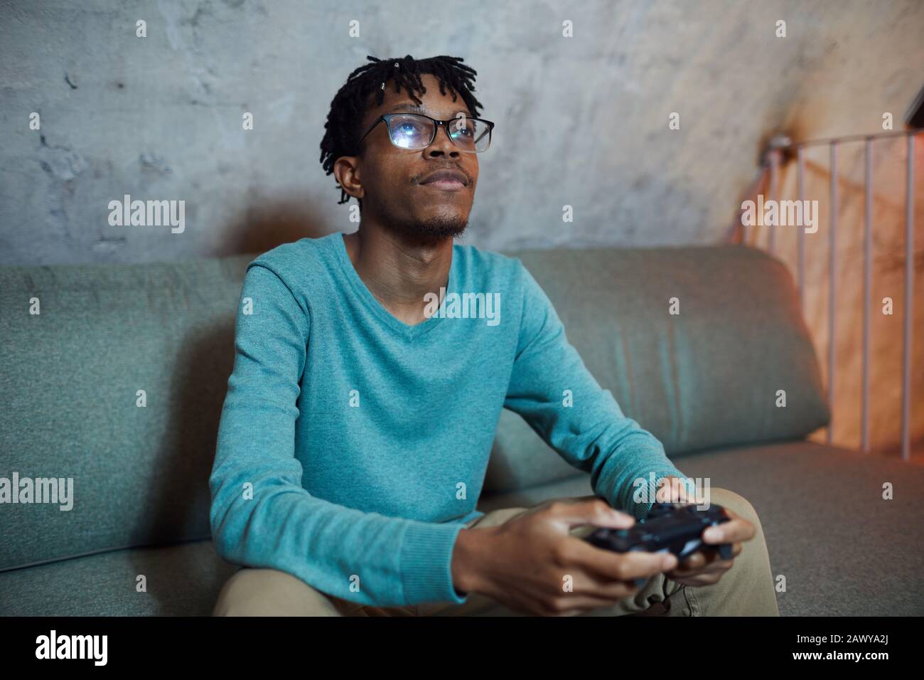 Portrait of smiling African-American man playing videogames via gaming console, copy space Stock Photo