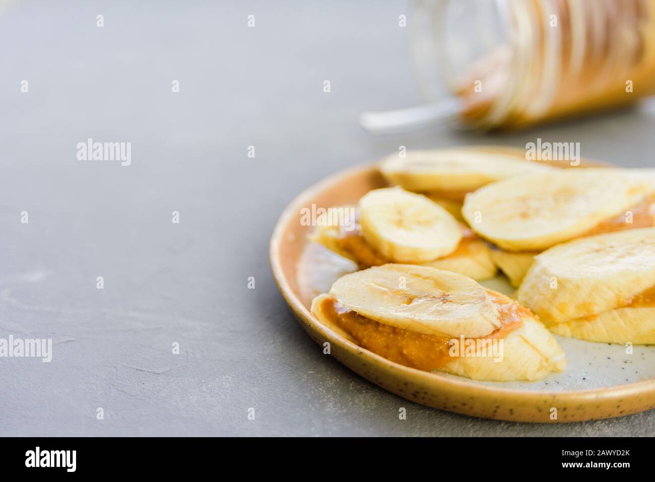 Image showcasing Banana with peanut butter on plate. Healthy snack Stock Photo - Alamy