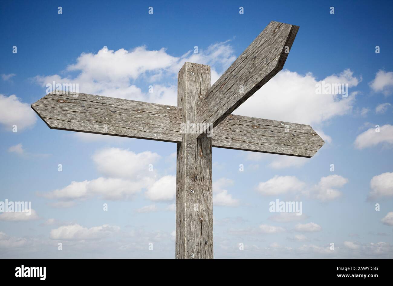 Blank three way wooden signpost against a blue sky Stock Photo