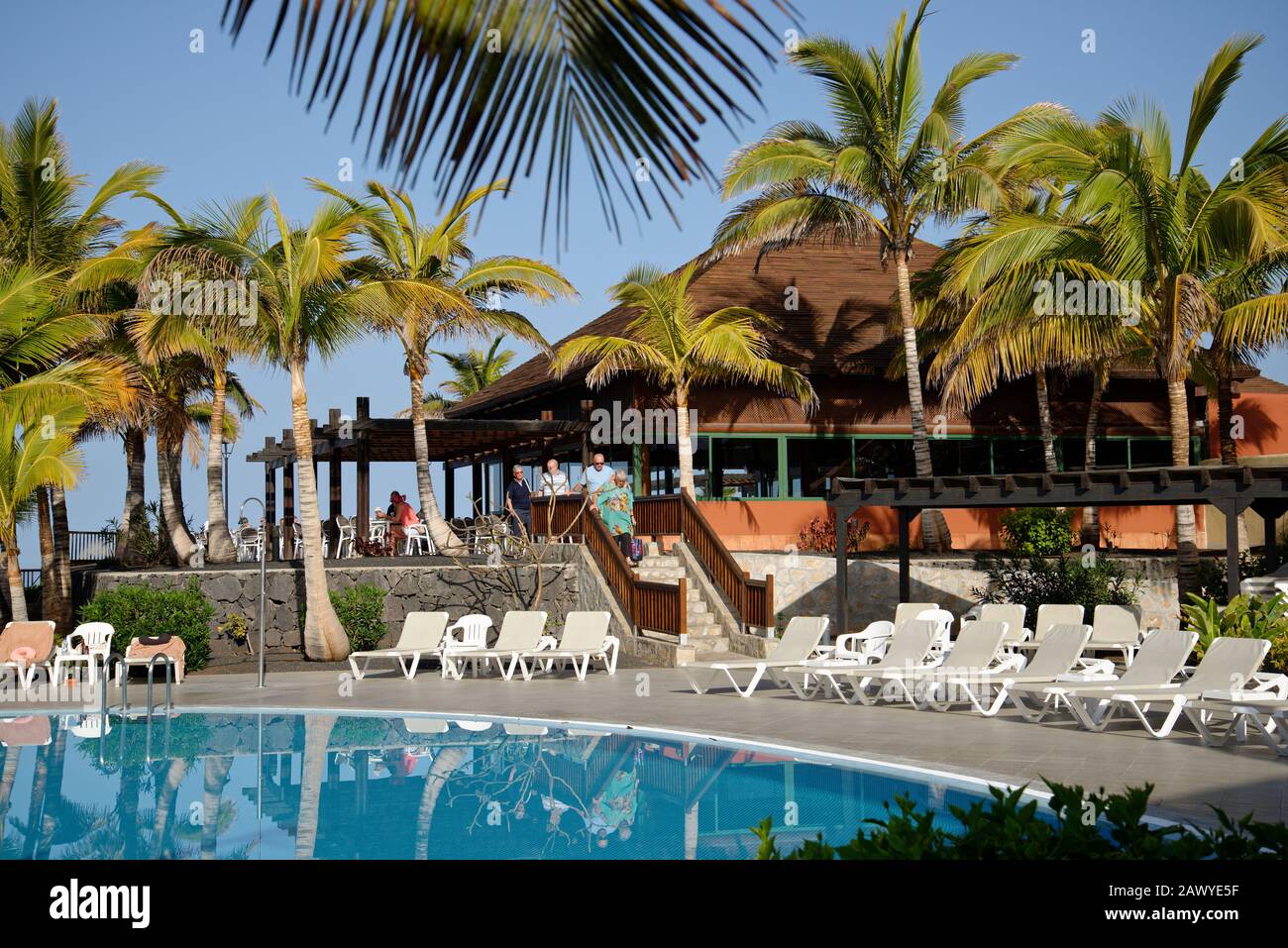 Holiday resort general picture. Resort buildings, palm trees and swimming pool. Stock Photo