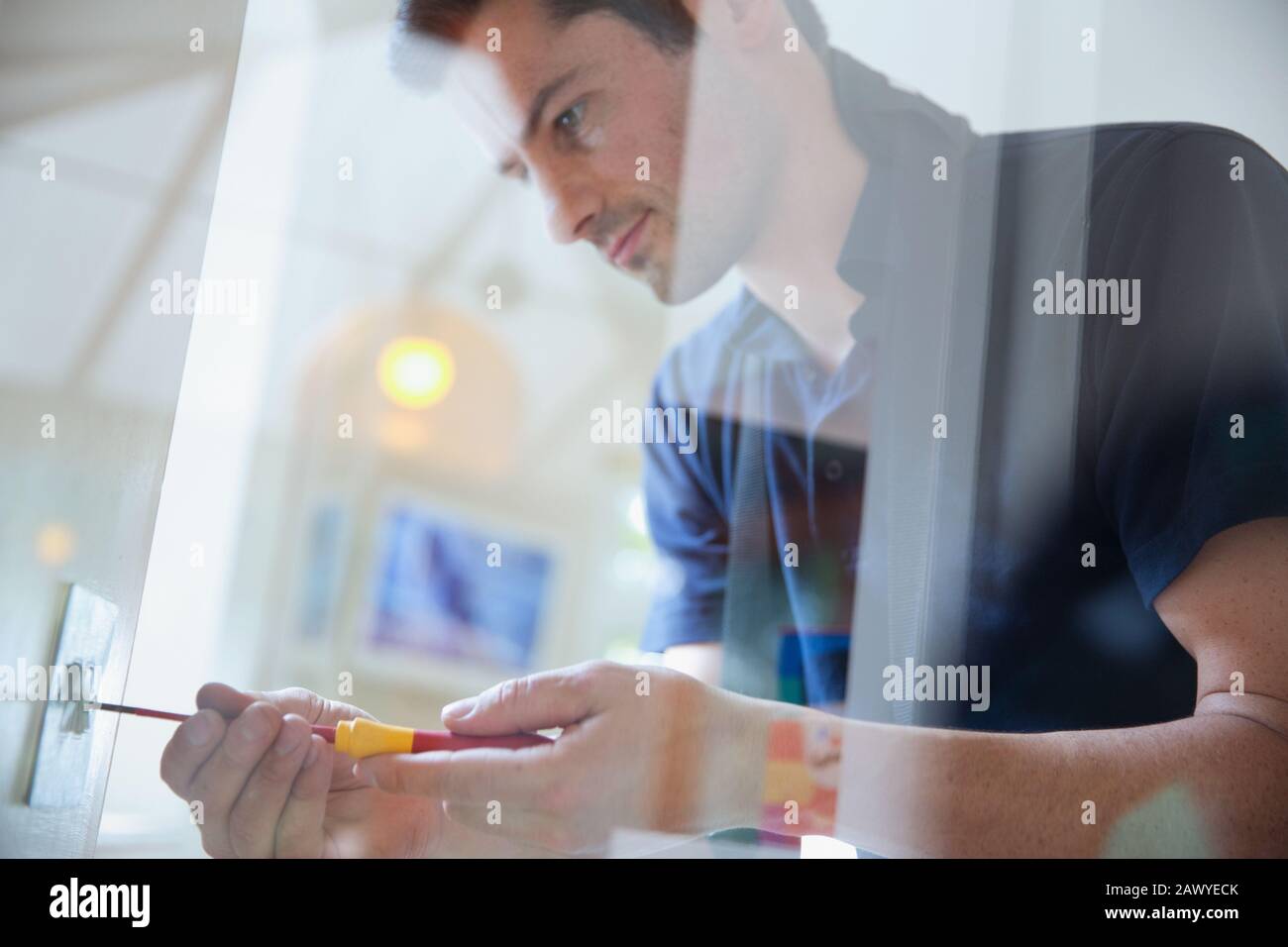 Electrician changing light fixture with screwdriver Stock Photo Alamy