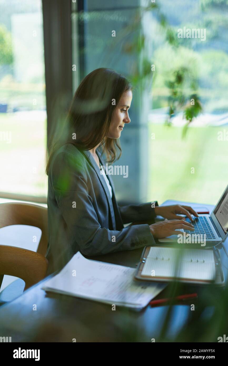 Focused businesswoman working at laptop Stock Photo