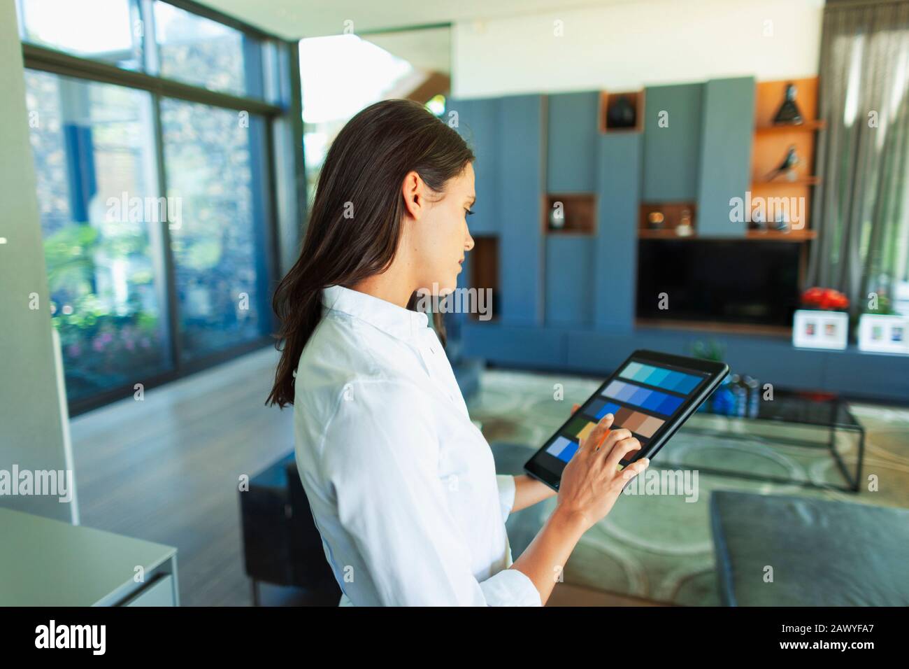 Female interior designer looking at digital color swatches on digital tablet Stock Photo