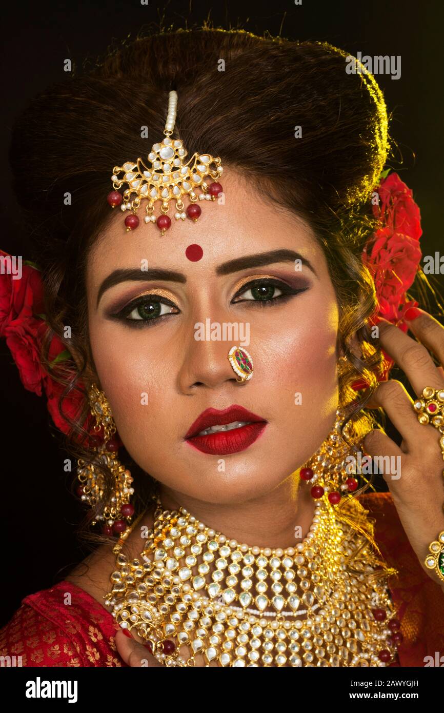 Portrait of an young and beautiful Indian Bengali brunette woman in red ...