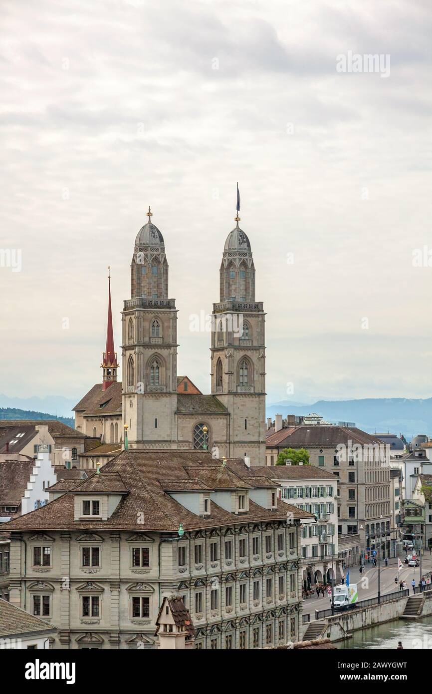 Zurich, Switzerland - June 10, 2017: The Grossmunster with town hall in front. It is a Romanesque-style Protestant church in Zurich, Switzerland. View Stock Photo