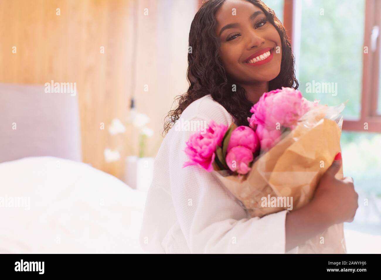 Portrait happy young woman with bouquet of pink peony flowers Stock Photo