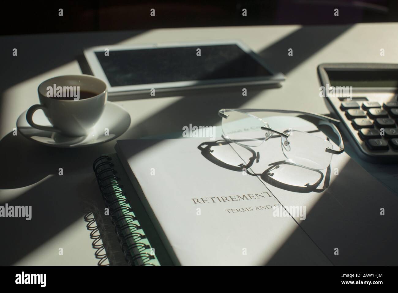 Retirement portfolio on sunny desk with coffee and eyeglasses Stock Photo