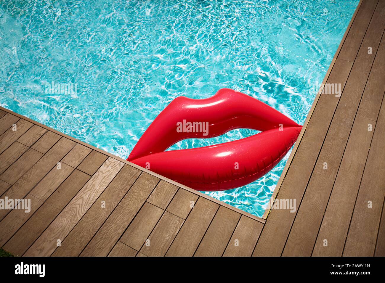 Inflatable lips floating in sunny summer swimming pool Stock Photo