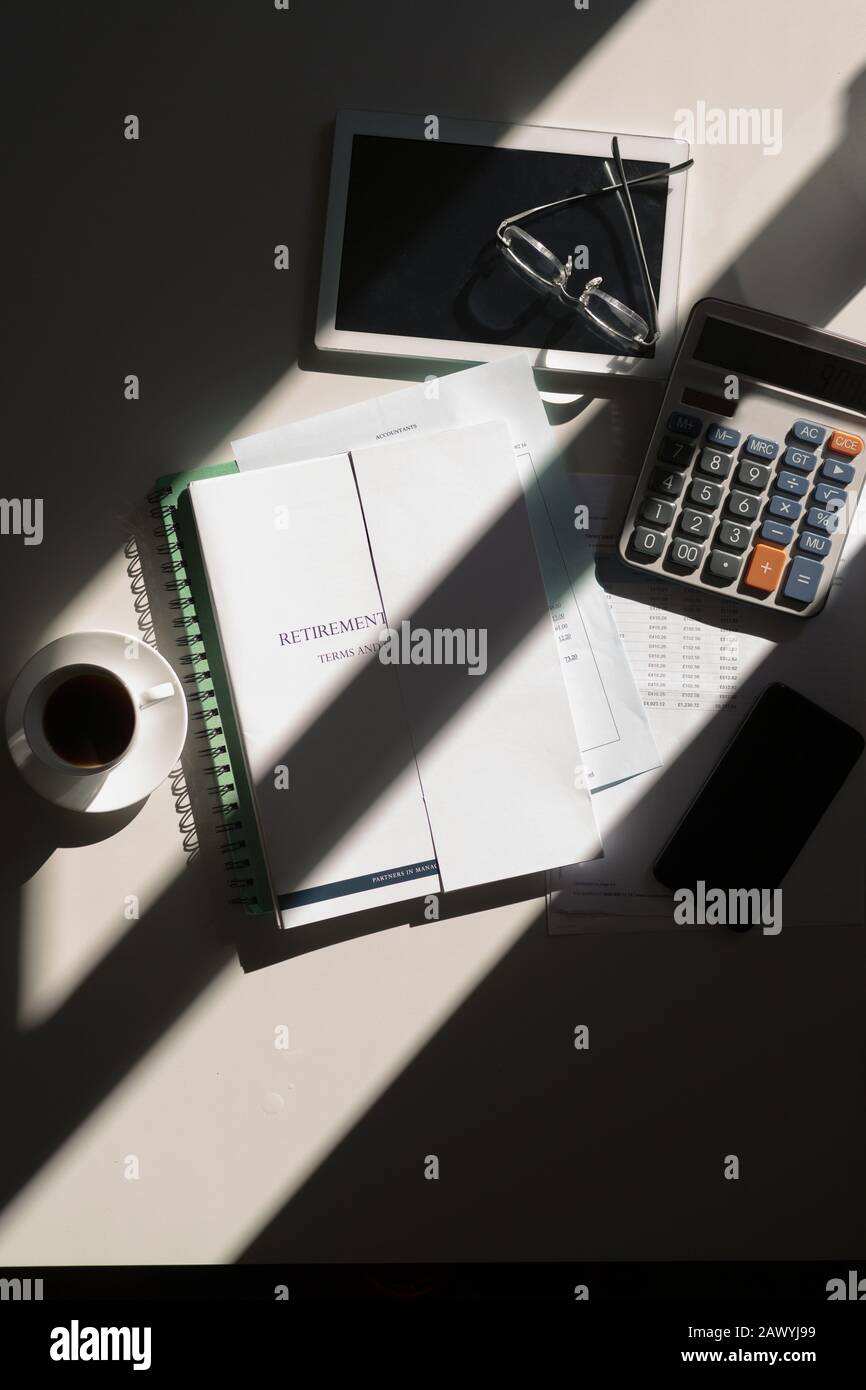 Retirement portfolio on sunny table with calculator and coffee Stock Photo