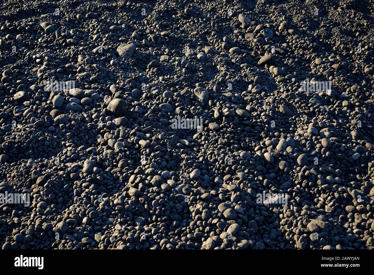 Volcanic rock pebbles on a beach. Suitable for a background. Stock Photo