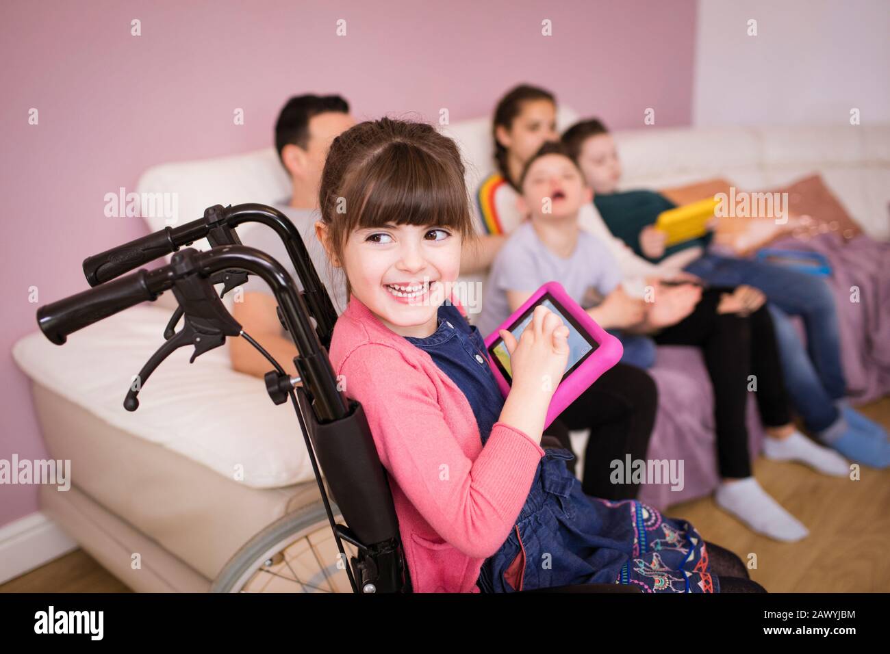 Happy young girl in wheelchair using digital tablet Stock Photo - Alamy