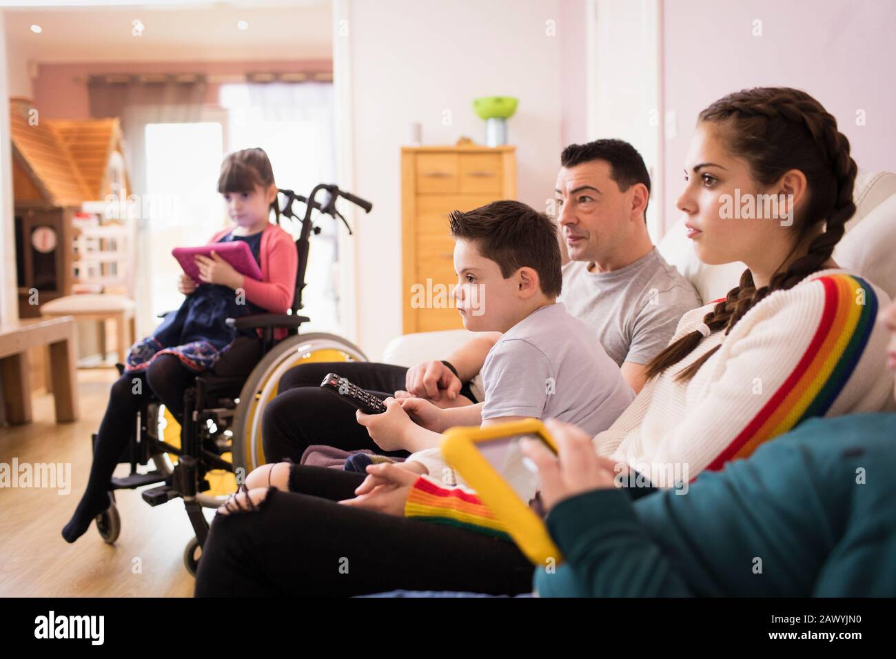 Family watching TV on living room sofa Stock Photo