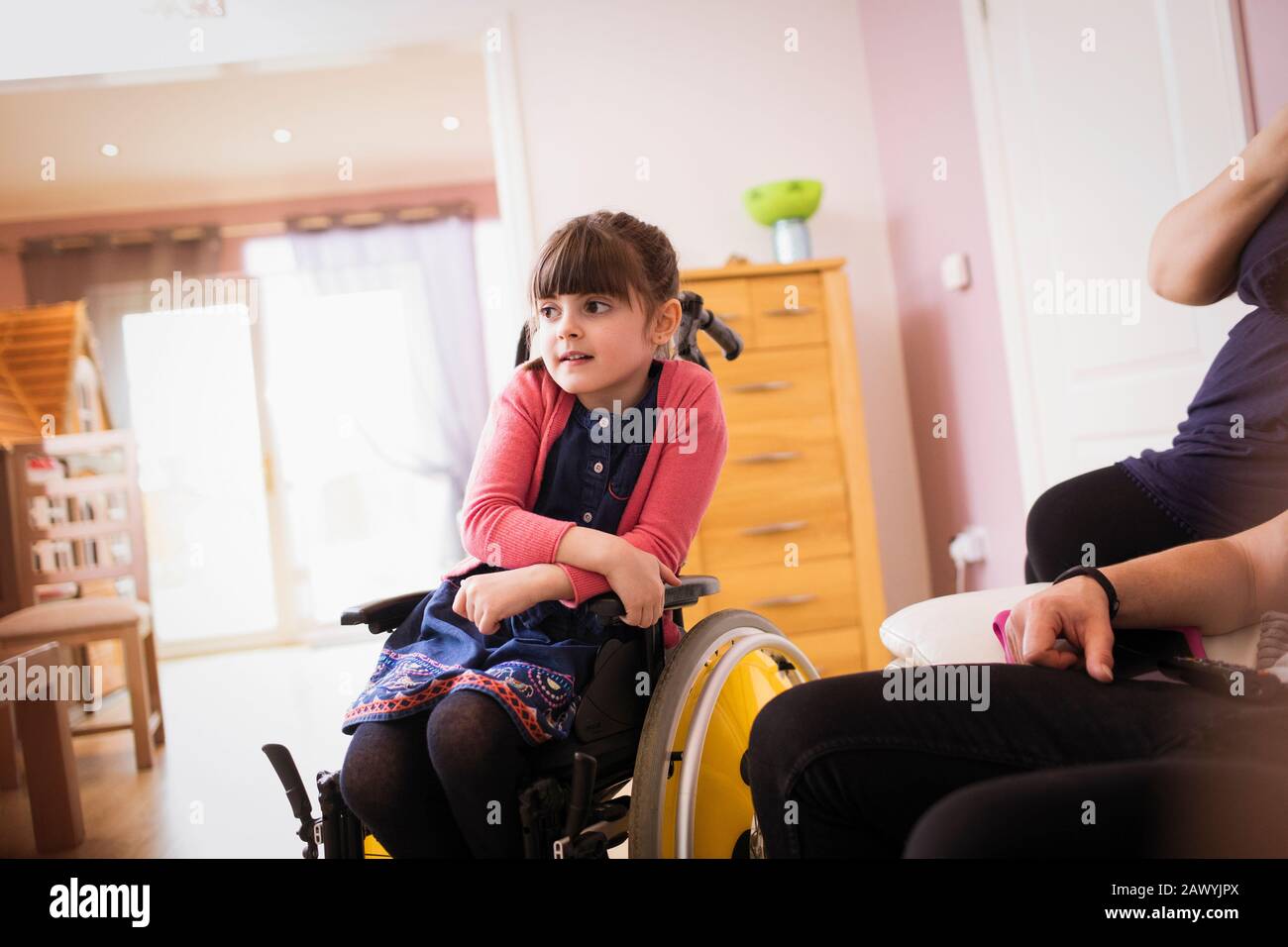 Girl in wheelchair watching TV in living room Stock Photo Alamy