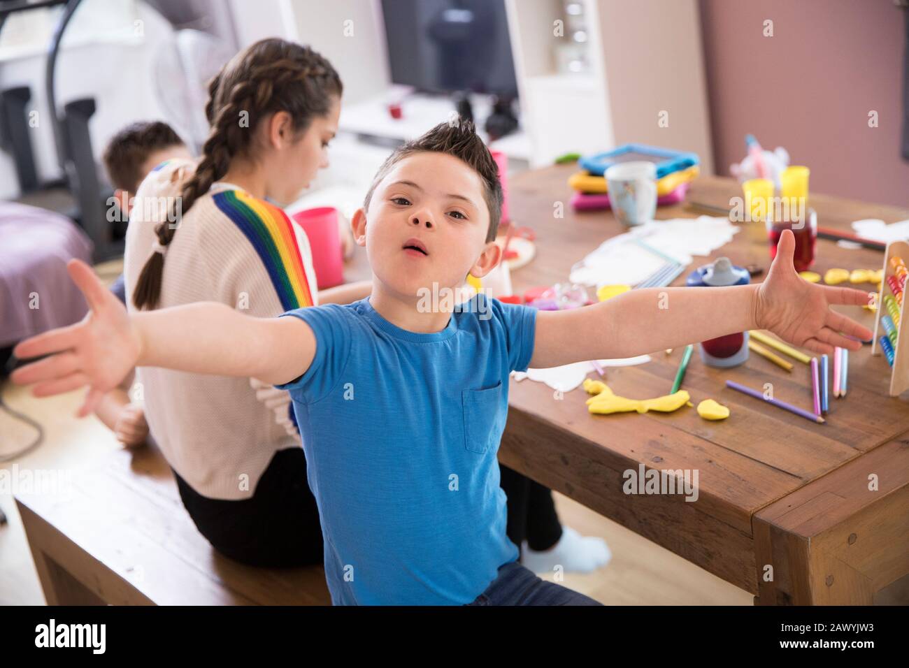 Portrait playful boy with Down Syndrome playing at dining table Stock Photo