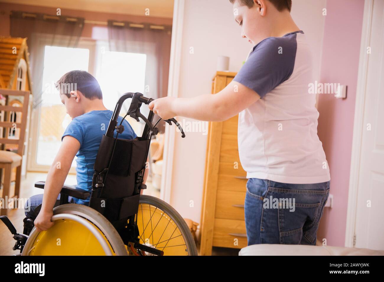 Boy pushing brother in wheelchair Stock Photo