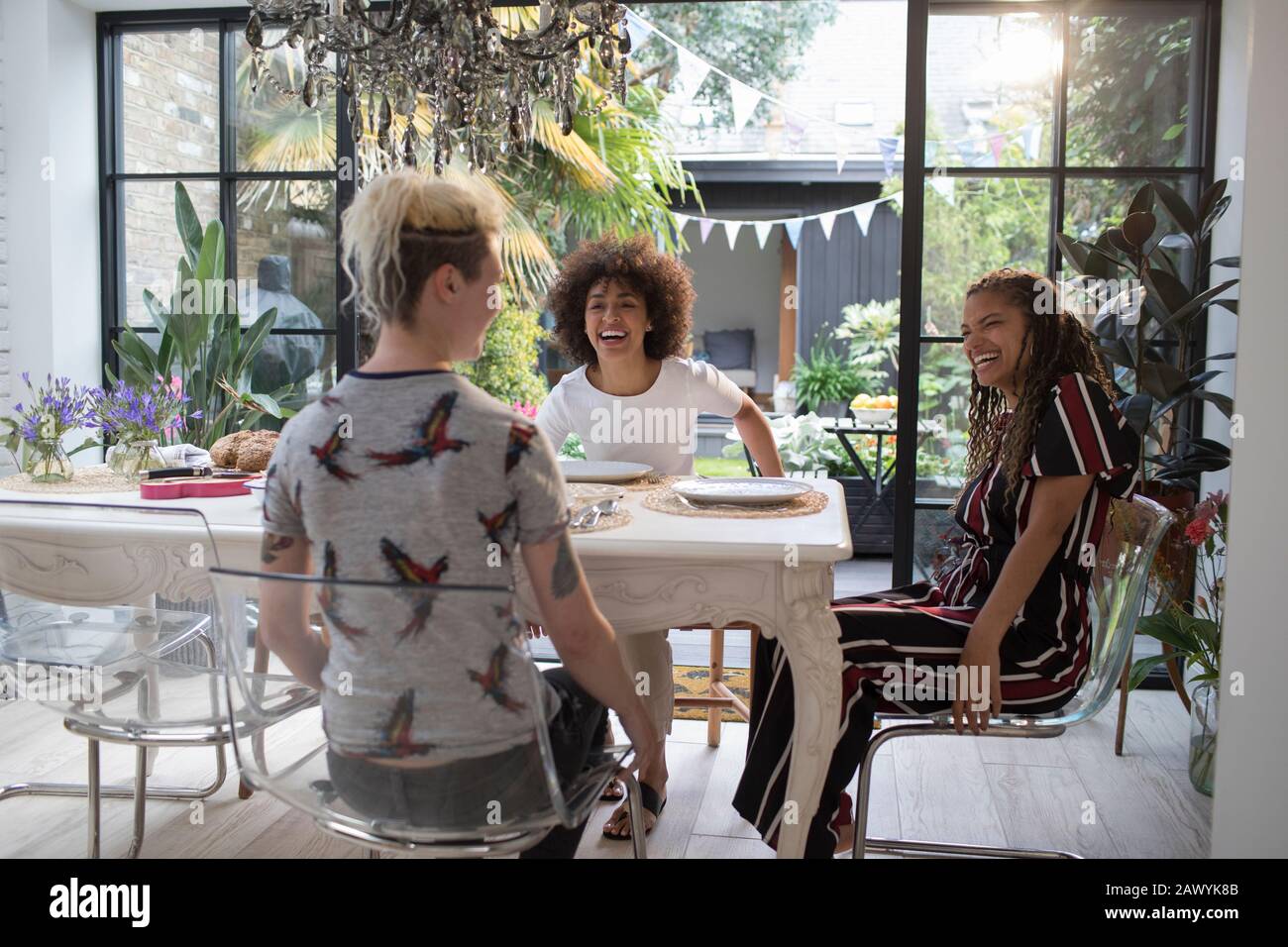 Happy young women friends at sunny dining room table Stock Photo