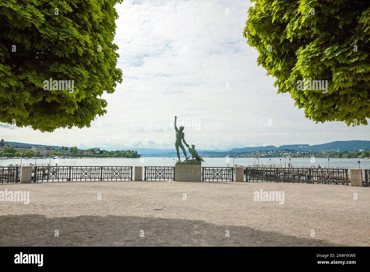 Zurich, Switzerland - June 10, 2017: Ganymed Statue (statue of a man and a eagle) in Zurich, Switzerland - Lake Zurich panorama in the background - wi Stock Photo