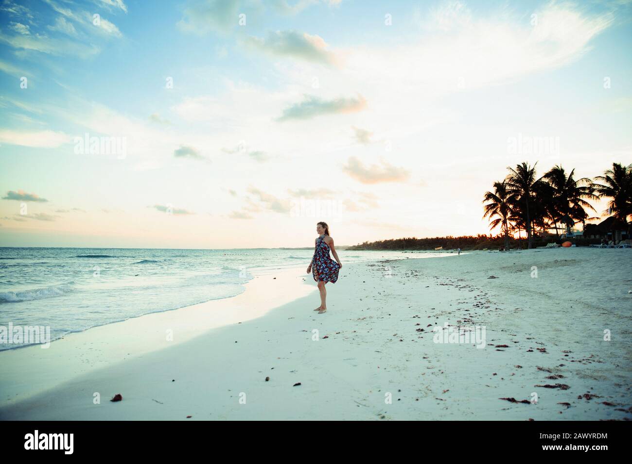 Carefree woman in sun dress on tropical ocean beach Mexico Stock Photo