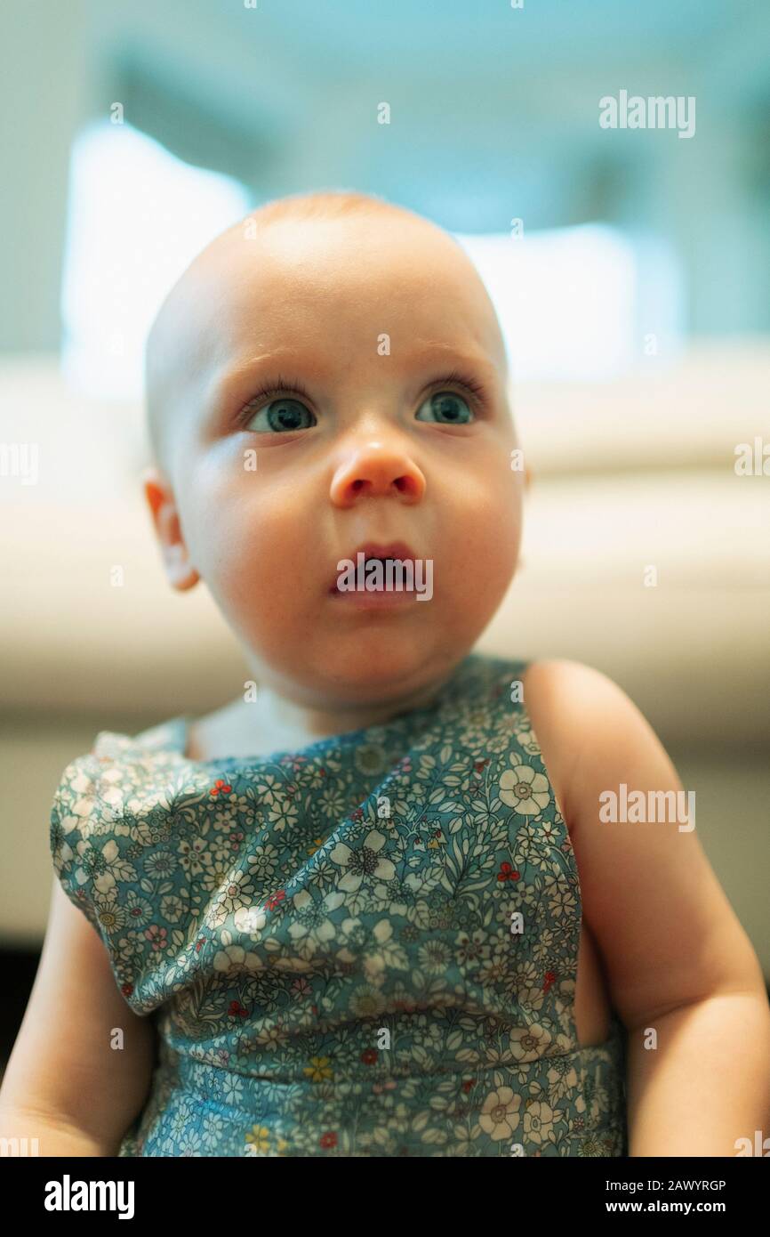 Cute curious baby girl looking away Stock Photo