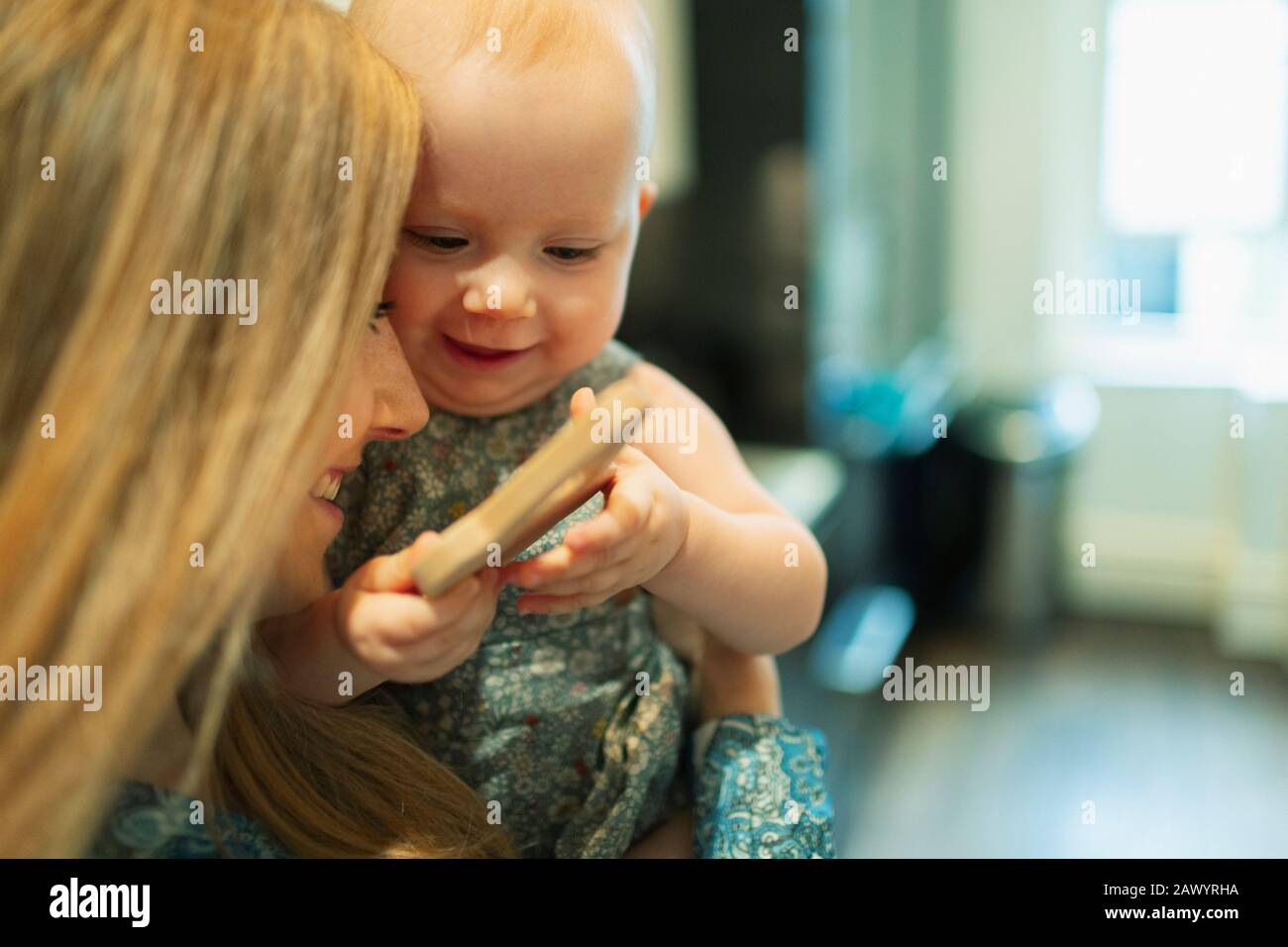 Mother holding cute baby girl with toy Stock Photo
