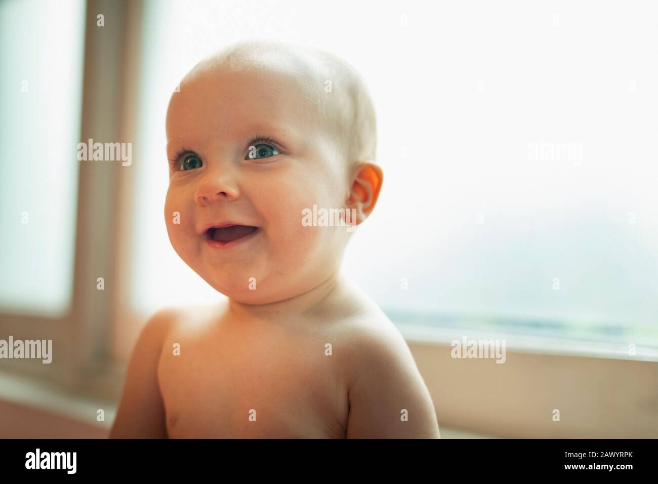 Cute curious baby girl looking up Stock Photo