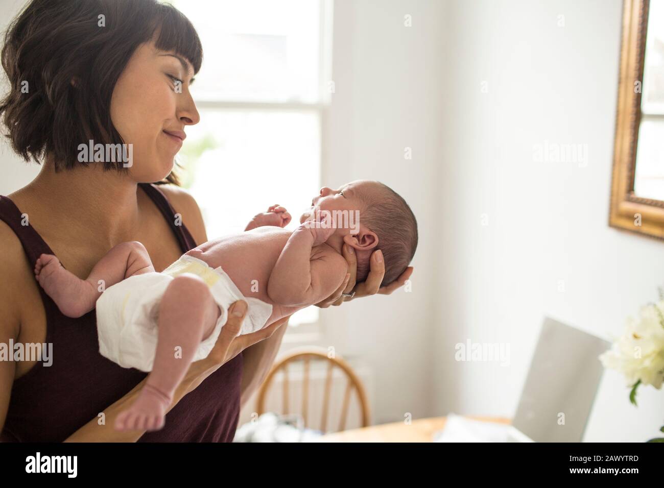 Mother cradling newborn baby son in diaper Stock Photo Alamy