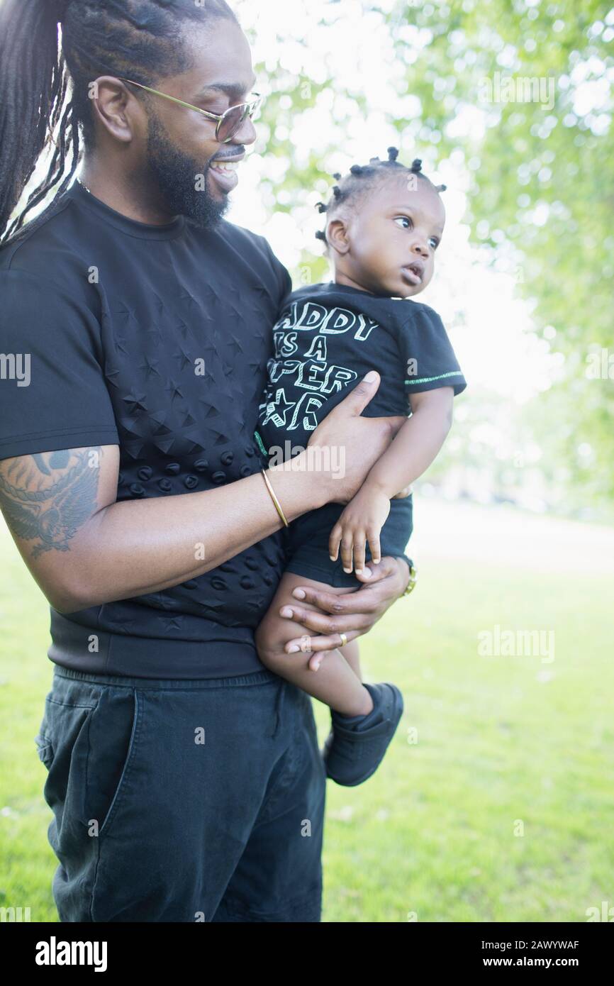 Father holding toddler son in park Stock Photo